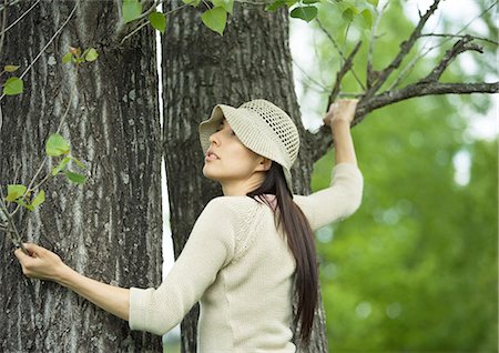 simsearch:696-03395998,k - Young woman holding on to tree Stock Photo - Premium Royalty-Free, Code: 696-03400353