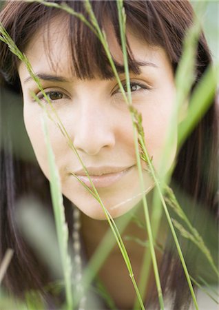 Woman's face seen through blades of grass Stock Photo - Premium Royalty-Free, Code: 696-03400391