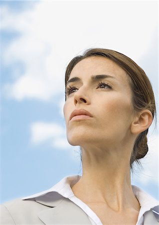 Woman looking into distance, portrait, low angle view Stock Photo - Premium Royalty-Free, Code: 696-03400511