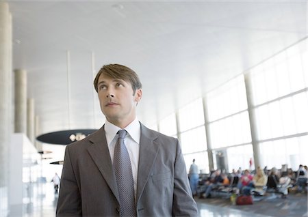 simsearch:695-03388701,k - Businessman in airport, looking up Stock Photo - Premium Royalty-Free, Code: 696-03400542