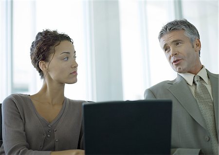 simsearch:632-01155400,k - Two business colleagues having discussion and using laptop Stock Photo - Premium Royalty-Free, Code: 696-03400587