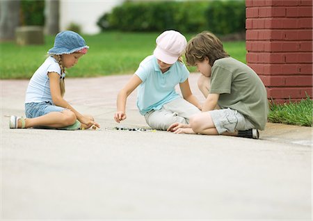 Enfants jouant des billes dans la rue Photographie de stock - Premium Libres de Droits, Code: 696-03400768