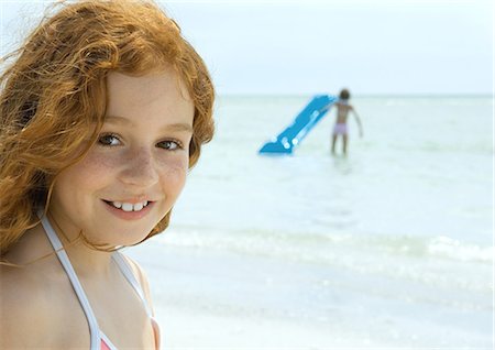 Girl smiling, ocean in background Stock Photo - Premium Royalty-Free, Code: 696-03400794