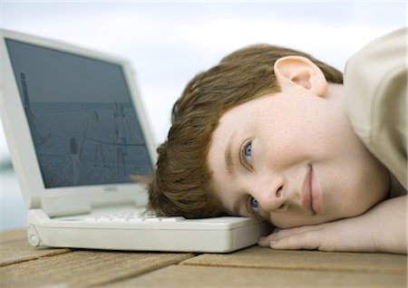 Boy resting head on laptop Stock Photo - Premium Royalty-Free, Code: 696-03400814