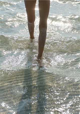 slim child - Girl walking through surf, low section Stock Photo - Premium Royalty-Free, Code: 696-03400810