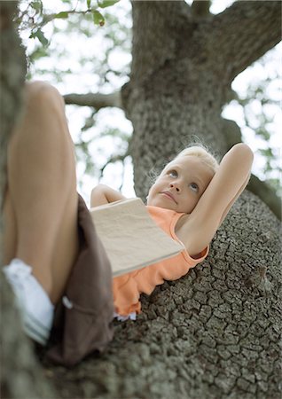 simsearch:632-02345008,k - Girl reclining in tree with book on stomach Stock Photo - Premium Royalty-Free, Code: 696-03400820