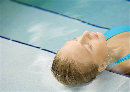 simsearch:632-03193618,k - Woman reclining in pool, head on steps Stock Photo - Premium Royalty-Free, Code: 696-03400863