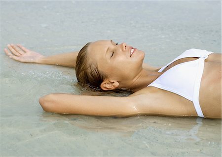 simsearch:649-08479729,k - Woman lying in shallow water on beach, eyes closed Stock Photo - Premium Royalty-Free, Code: 696-03400898