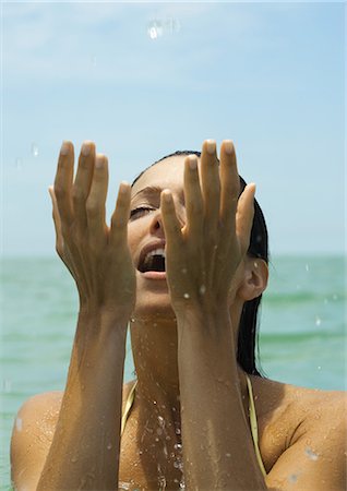 simsearch:632-01146602,k - Woman in water splashing in water, eyes closed Stock Photo - Premium Royalty-Free, Code: 696-03400892