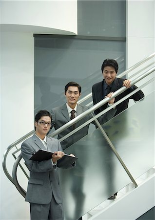 simsearch:695-03388914,k - Three business executives standing along staircase, looking at camera Foto de stock - Sin royalties Premium, Código: 696-03401097
