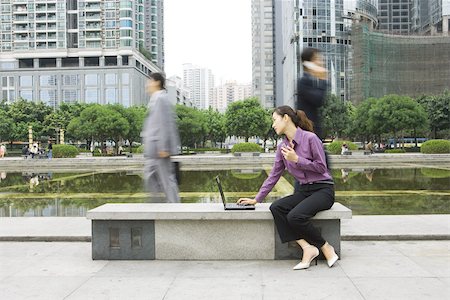 simsearch:696-03401126,k - Jeune femme avec ordinateur portable à l'extérieur sur banc public office Photographie de stock - Premium Libres de Droits, Code: 696-03401110