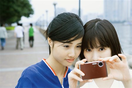 simsearch:400-04900515,k - Two young friends taking photo with digital camera Stock Photo - Premium Royalty-Free, Code: 696-03401153