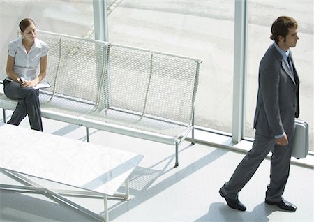 Lobby, woman sitting while businessman passes with briefcase, full length, high angle view Foto de stock - Sin royalties Premium, Código: 696-03401190