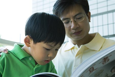 Father and son reading book Stock Photo - Premium Royalty-Free, Code: 696-03401226