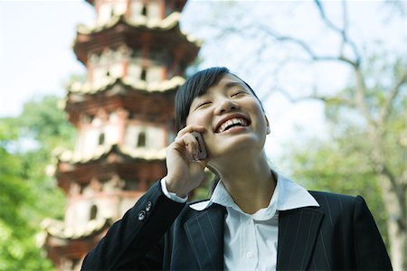 simsearch:632-01271089,k - Woman using cell phone, pagoda in background Stock Photo - Premium Royalty-Free, Code: 696-03401253