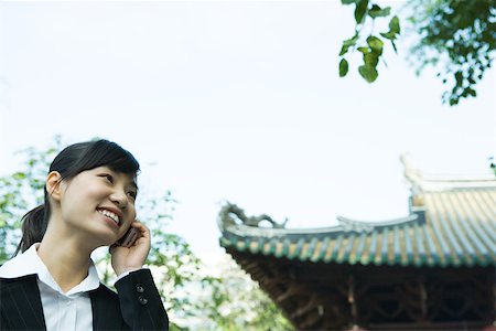 simsearch:632-01271089,k - Woman using cell phone, traditional Chinese building in background Stock Photo - Premium Royalty-Free, Code: 696-03401260