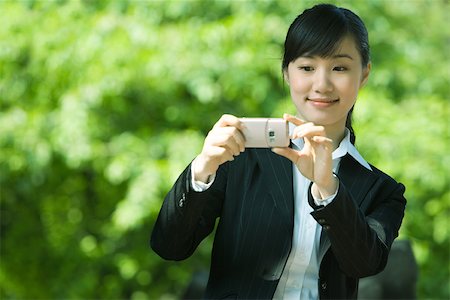 Woman taking photo with phone Stock Photo - Premium Royalty-Free, Code: 696-03401280