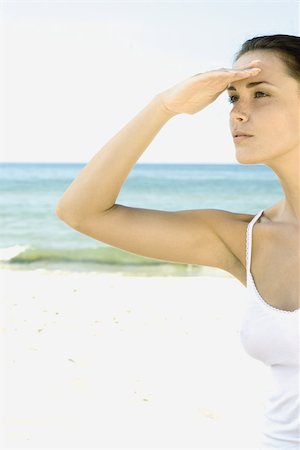 simsearch:696-03395430,k - Woman shading eyes, looking away beach in background Foto de stock - Royalty Free Premium, Número: 696-03401378