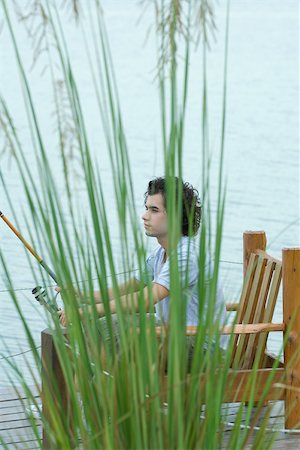 Young man sitting on dock, fishing Stock Photo - Premium Royalty-Free, Code: 696-03401389