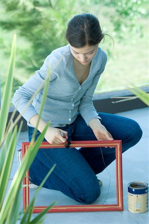 Young woman painting picture frame outdoors Stock Photo - Premium Royalty-Free, Code: 696-03401393