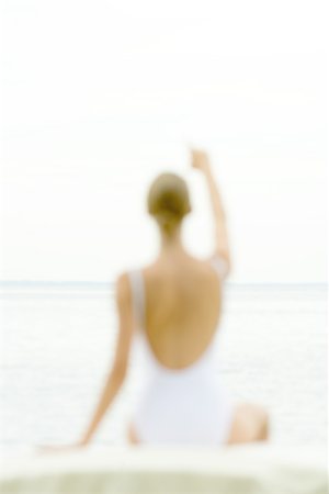 simsearch:696-03402108,k - Female figure wearing bathing suit, blurred silhouette, pointing toward sea in background, rear view Stock Photo - Premium Royalty-Free, Code: 696-03401413