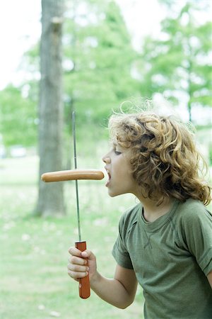 Boy eating hotdog Stock Photo - Premium Royalty-Free, Code: 696-03401434