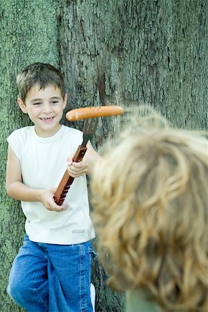 simsearch:696-03401434,k - Boy holding hot dog on end of large fork, showing friend Stock Photo - Premium Royalty-Free, Code: 696-03401436
