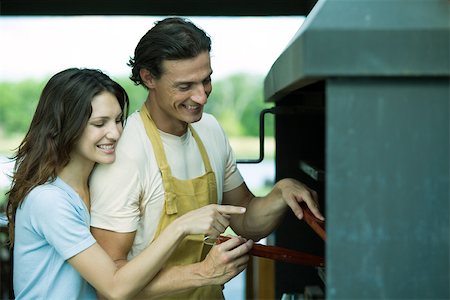 simsearch:696-03401434,k - Couple having cookout together, woman pointing to barbecue Stock Photo - Premium Royalty-Free, Code: 696-03401443