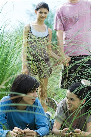 simsearch:693-06668076,k - Group of young friends, two lying in grass while two stand behind them Stock Photo - Premium Royalty-Free, Code: 696-03401492
