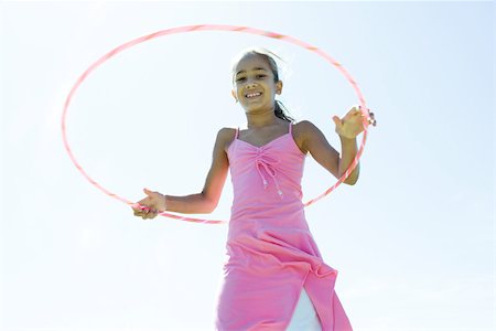 Girl playing with plastic hoop Stock Photo - Premium Royalty-Free, Code: 696-03401526