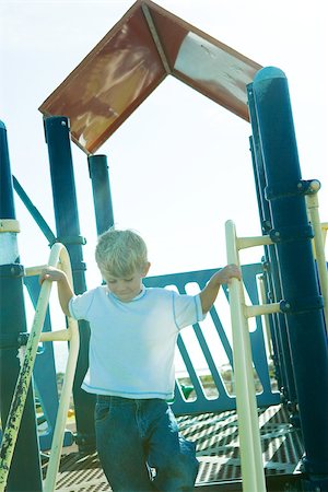 Boy on playground equipment, holding onto railing Stock Photo - Premium Royalty-Free, Code: 696-03401536