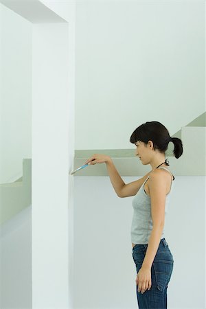 Woman painting wall with paint brush Stock Photo - Premium Royalty-Free, Code: 696-03401597
