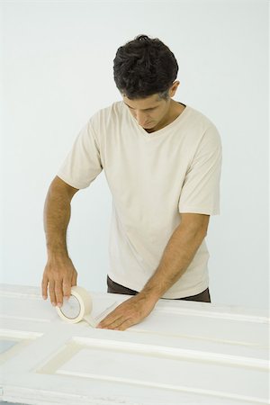 designer of interior decoration - Man putting masking tape on door Stock Photo - Premium Royalty-Free, Code: 696-03401601