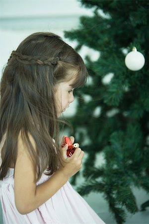 people decorate christmas tree - Girl looking at Christmas tree Stock Photo - Premium Royalty-Free, Code: 696-03401645