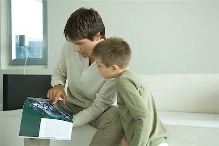 Father and son looking at magazine together Stock Photo - Premium Royalty-Free, Code: 696-03401652