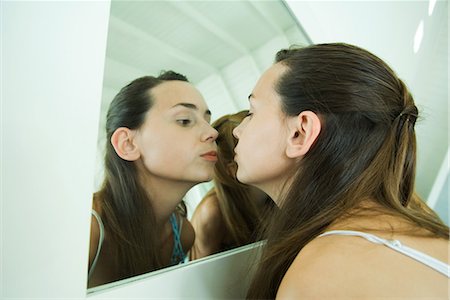 puckered lips profile - Teenage girl looking at self in mirror, kissing her reflection Stock Photo - Premium Royalty-Free, Code: 696-03401721