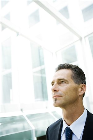 Businessman looking away, head and shoulders, portrait Stock Photo - Premium Royalty-Free, Code: 696-03401739
