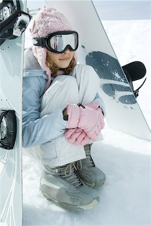 ski boots - Preteen girl sitting on snow underneath propped up snowboards Stock Photo - Premium Royalty-Free, Code: 696-03401790