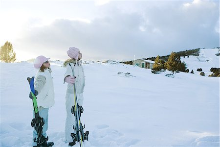 skiing chalet - Two young friends standing together, holding skis, looking away Stock Photo - Premium Royalty-Free, Code: 696-03401831