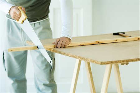 saw - Man sawing wood with saw, cropped view Stock Photo - Premium Royalty-Free, Code: 696-03401882