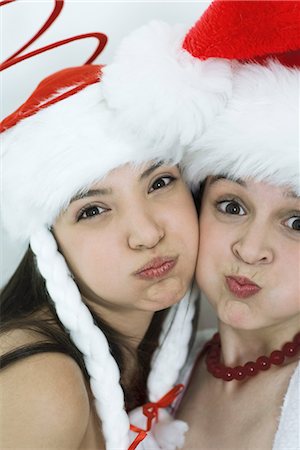 Two young female friends dressed in Christmas costumes, puffing out cheeks, looking at camera, portrait Foto de stock - Sin royalties Premium, Código: 696-03401918