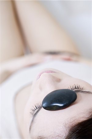 simsearch:633-02128630,k - Woman lying on back with pebble on forehead, eyes closed Foto de stock - Sin royalties Premium, Código: 696-03401968