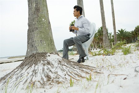 palm tree trunk - Man sitting in chair on beach looking at view, holding binoculars Stock Photo - Premium Royalty-Free, Code: 696-03402079