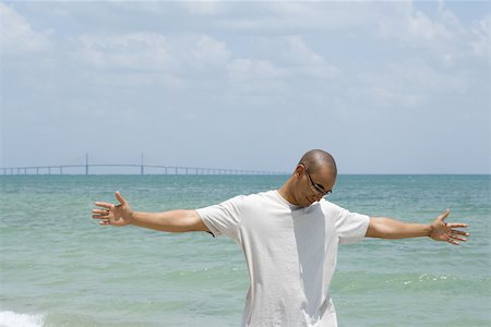 simsearch:696-03402108,k - Man standing at the beach with arms outstretched, looking down Stock Photo - Premium Royalty-Free, Code: 696-03402102