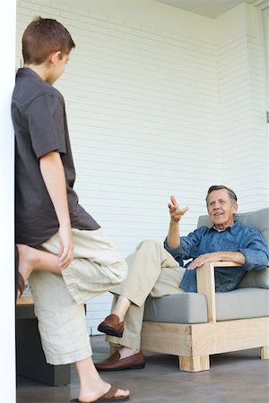Grandfather and grandson chatting on patio together Stock Photo - Premium Royalty-Free, Code: 696-03402180