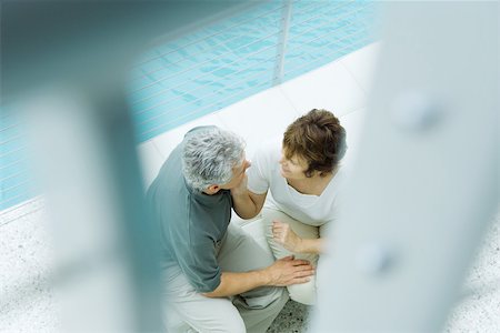 simsearch:632-05816872,k - Couple sitting next to pool, high angle view, selective focus Stock Photo - Premium Royalty-Free, Code: 696-03402216