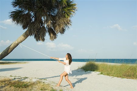 Woman pulling palm tree with rope Foto de stock - Sin royalties Premium, Código: 696-03402296