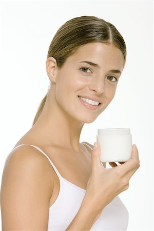 simsearch:632-01147199,k - Woman holding up jar of skin cream, smiling at camera Foto de stock - Sin royalties Premium, Código: 696-03402348