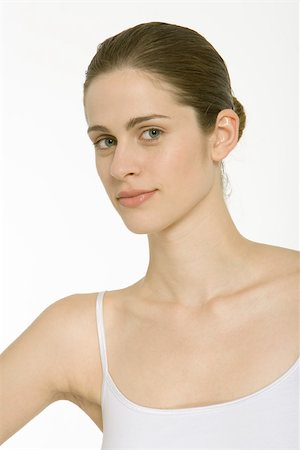 Woman with hair in bun, wearing white tank top, portrait Stock Photo - Premium Royalty-Free, Code: 696-03402350