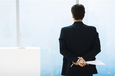 Businessman preparing to give speech, looking out of window Stock Photo - Premium Royalty-Free, Code: 696-03402412